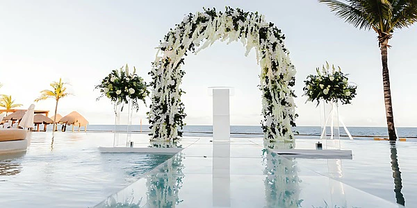 Over the Water wedding ceremony setup with floral arch at Secrets Riviera Cancun