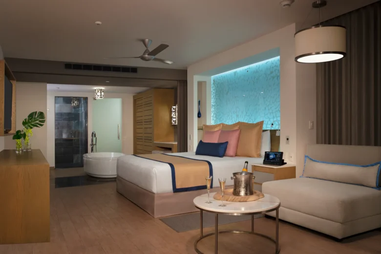 Preferred Club Master Suite Swim Out Ocean Front bedroom with king bed and spa-style bathroom at Secrets Riviera Cancun.