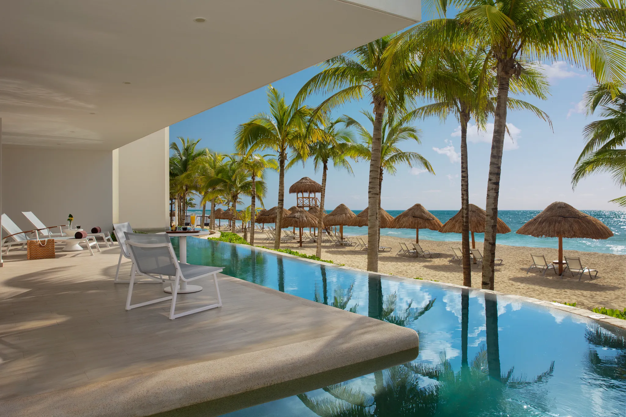 Preferred Club Master Suite Swim Out Ocean Front terrace with infinity-style swim-up pool overlooking the beach at Secrets Riviera Cancun.