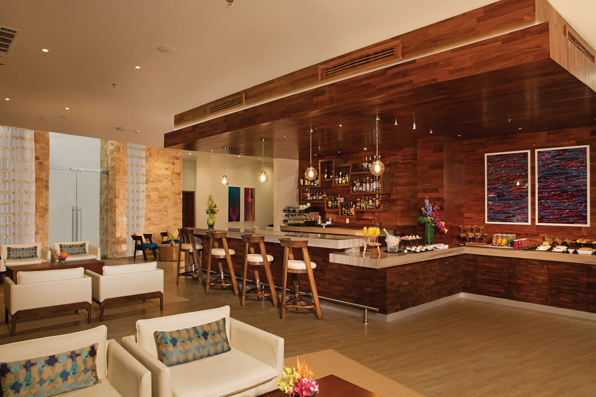 Elegant indoor lounge and bar at Secrets Riviera Cancun Resort & Spa featuring warm wood décor, craft cocktails, and relaxed adults-only ambiance.